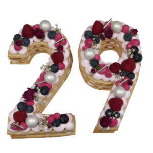 Dreischichtige Nummertorte "29" aus Keks und Buttercremetupfen mit Streuseln, frischen Früchten und Rosen